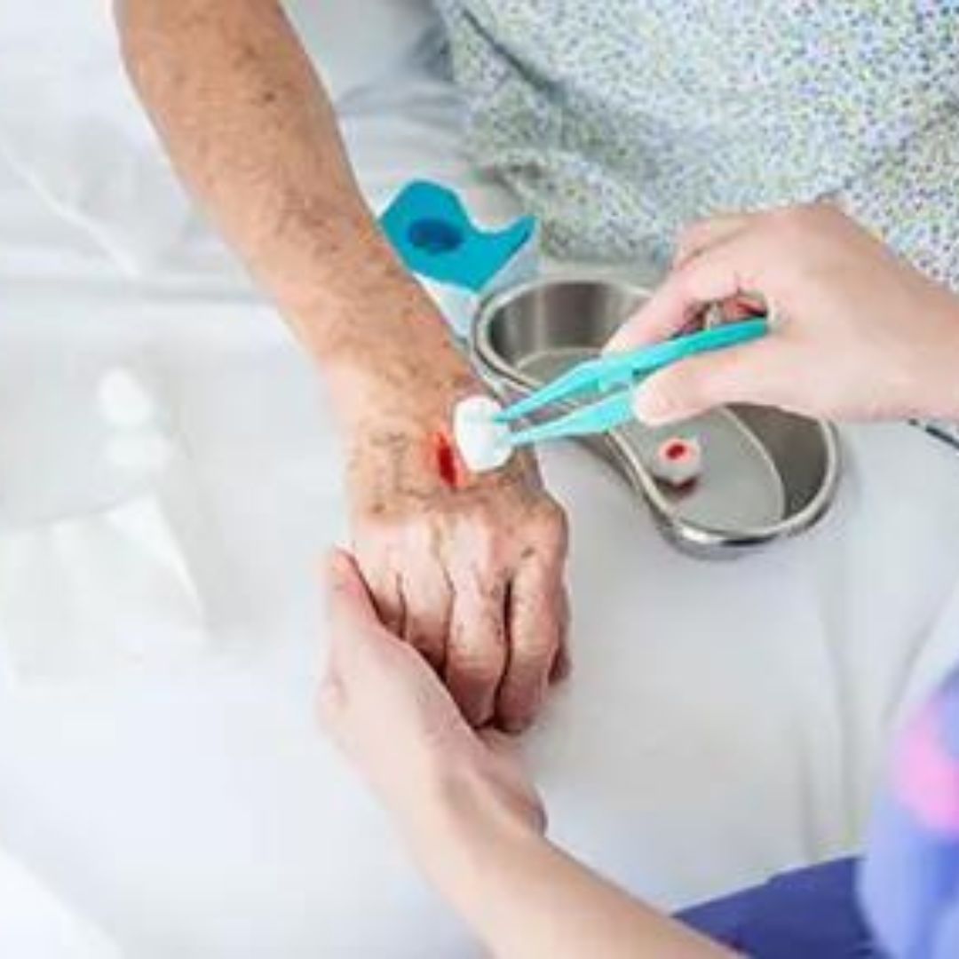 Healthcare professional applying antiseptic to an elderly patient's hand, showcasing compassionate care in a clinical setting.